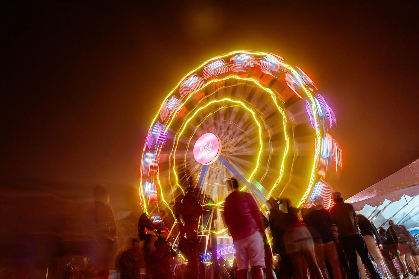 A lit-up Ferris wheel on the beach at night in Rosarito